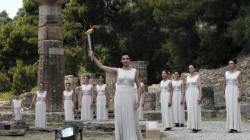 Esta sacerdotisa sostiene la antorcha  que fue encendida ayer en la antigua Olimpia para comenzar su recorrido de 2,896 kilómetros.