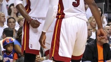 Chris Bosh (de frente) y Dwyane Wade (3), del Miami Heat, celebran la cuarta derrota sobre los Knicks  en la primera ronda de los playoffs de la NBA.