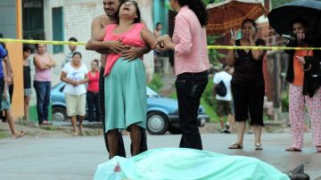 Perfecta Reyes llora en el lugar donde ayer fue asesinado su hijo José César Reyes, en un barrio de Tegucigalpa (Honduras).