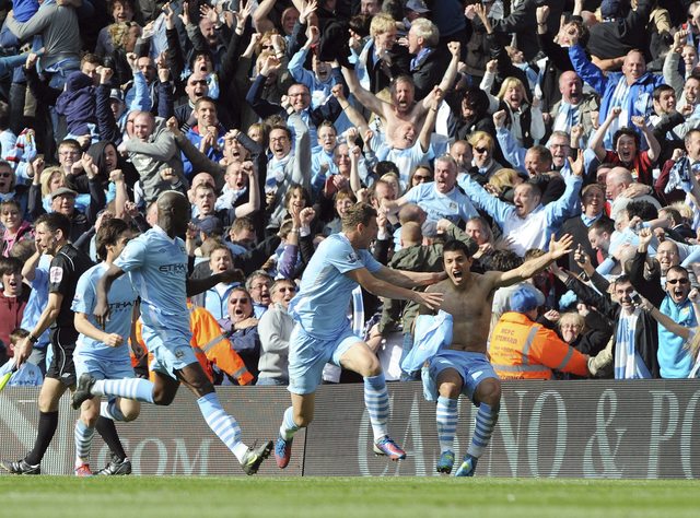 El argentino  Sergio Agüero celebra con sus compañeros tras marcar el gol de la victoria del Manchester City 3-2 sobre el  Queens Park Rangers, el cual le daría el título a su equipo, su primer campeonato en los últimos 44 años.