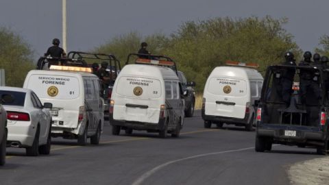 La policía federal escolta a los camiones de forenses con decenas de cuerpos, algunos de ellos mutilados, encontrados en una carretera en la ciudad de San Juan, cerca de Monterrey, México.