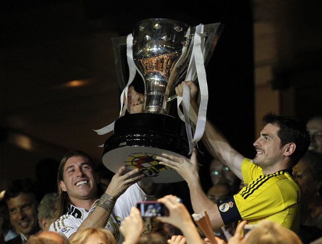 Los jugadores Sergio Ramos (izq.) e Iker Casillas levantan el trofeo de campeones de  la liga española 2011-2012  obtenido por el Real Madrid.
