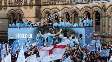 Jugadores del Manchester City disfrutan del festejo ayer junto a sus seguidores.