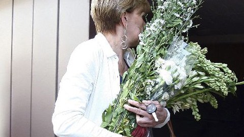 Una mujer lleva flores a la casa del mexicano Carlos Fuentes donde serán velados los restos del escritor.