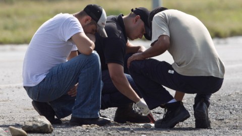 Forenses inspeccionan el lugar donde fueron encontrados los 49 cadáveres.