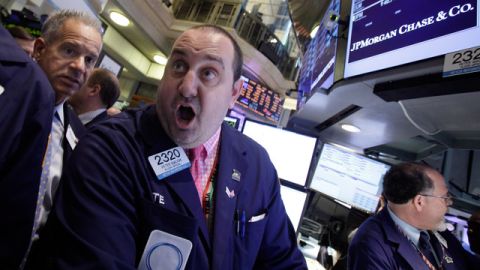 El especialista de mercado, Peter Giacchi (centro), reacciona a la pérdida de $2 mil millones del banco el pasado viernes.
