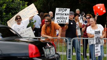 Manifestantes permanecen en las afueras de la puerta de JPMorgan Chase después de la reunión anual de  accionistas ayer en Tampa, Florida
