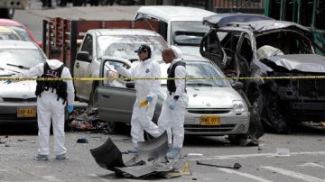 Peritos forenses practican diligencias en el lugar donde explotó el carro bomba.
