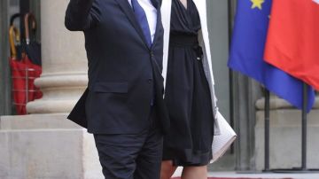 François Hollande, saluda  mientras sale del Palacio del Elíseo con su novia Valerie Trierweiler, tras la ceremonia del traspaso de poderes .