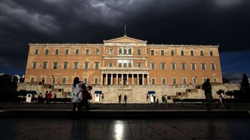 Personas caminan frente al Parlamento griego.