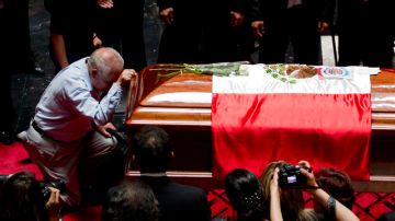 Un hombre se arrodilla ante el féretro  del difunto escritor  Carlos Fuentes, durante el homenaje que se le rindió ayer.