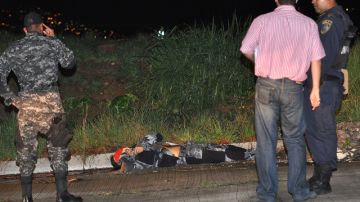 Policías observan el cadáver del periodista, Alfredo Villatoro asesinado por desconocidos en cautiverio.