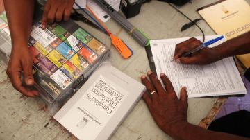 Miembros de un colegio electoral dominicano revisan un paquete con votos  en la sede la Junta Central Electoral del Distrito Nacional en Santo Domingo.