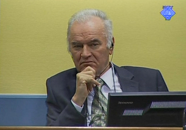 El exgeneral serbio bosnio Ratko Mladi escucha las acusaciones de la fiscalía  en su contra por genocidio, crímenes de guerra y contra la humanidad.