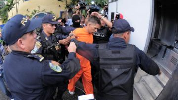 El recluso Juan Ramón Fonseca (c) es escoltado en una instalación policial en Tegucigalpa (Honduras), investigados por el asesinato del periodista.