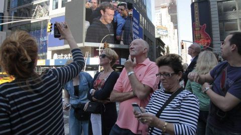 El fundadorde Facebook, Mark Zuckerberg (en la pantalla), hizo sonar hoy la campana con la que se da comienzo a la sesión en el mercado Nasdaq.