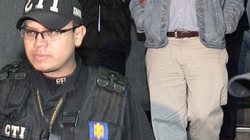 El exdiputado colombiano, Sigifredo López es escoltado por agentes de la fiscalía.