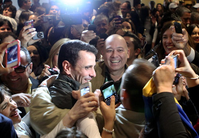 El candidato de la oposición a la Presidencia de Venezuela, Henrique Capriles (c), recibe el saludo de sus seguidores durante su visita a Bogotá.