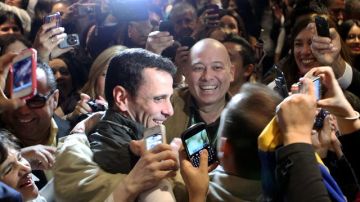 El candidato de la oposición a la Presidencia de Venezuela, Henrique Capriles (c), recibe el saludo de sus seguidores durante su visita a Bogotá.