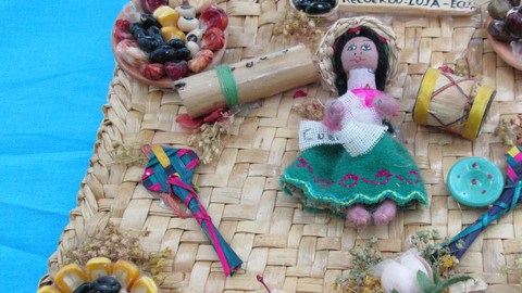 En el cuadro se ve una variedad de objetos típicos de la región de Loja, en Ecuador. Desde la típica campesina, como los alimentos característicos del área, sus flores  y otros productos artesanales.