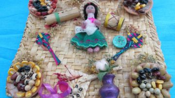 En el cuadro se ve una variedad de objetos típicos de la región de Loja, en Ecuador. Desde la típica campesina, como los alimentos característicos del área, sus flores  y otros productos artesanales.