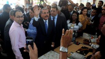 Danilo Medina, al centro, saluda tras depositar su voto en Santo Domingo.