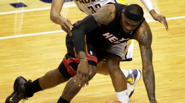 LeBron James, del Heat, pierde el control del balón, mientras Danny Granger(33), de los Pacers, le pone resistencia, durante el juego de ayer en la NBA.
