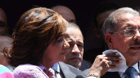 Cándida Montilla, esposa del presidente electo de República Dominicana, Danilo Medina, le seca el sudor del cuello mientras este ofrece su primer discurso.