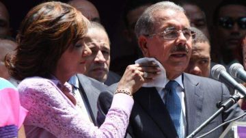 Cándida Montilla, esposa del presidente electo de República Dominicana, Danilo Medina, le seca el sudor del cuello mientras este ofrece su primer discurso.