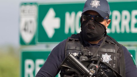 Un policía federal custodia la zona de la matanza, una carretera entre Monterrey y la frontera con EEUU.
