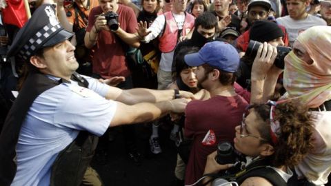 Manifestantes intentan detener a un policia de Chicago que trata de llevarse a preso a una persona.