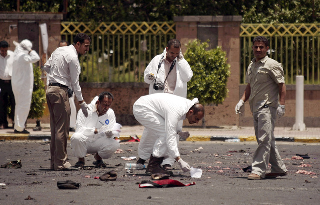 Policías forences recogen evidencias en el sitio donde se produjo el atentado en la ciudad yemení de Saná.