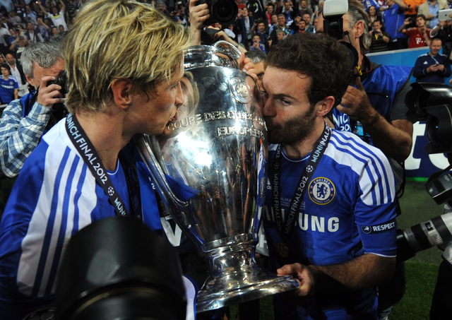 Los españoles Fernando Torres (izq.) y Juan Mata besan el trofeo de la Liga de Campeones de Europa ganada por el Chelsea ante el Bayern de Alemania.