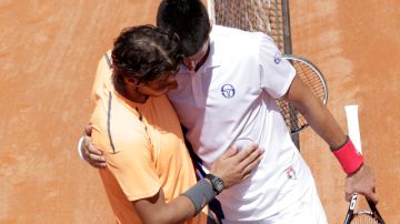 Rafa Nadal (izq.) y Novak Djokovic se abrazan tras el partido de ayer.