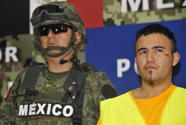 Un miembro del ejército  escolta a Daniel Elizondo Ramírez (d), alias "el Loco", en las instalaciones de la Subprocuraduría de Investigación Especializada en Delincuencia Organizada (SIEDO) de Ciudad de México (México).