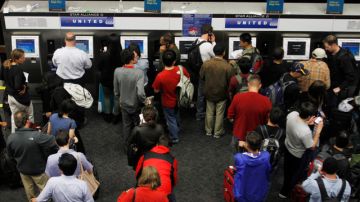 Viajeros hacen fila frente a una oficina de un empresa aérea en el aeropuerto internacional de San Francisco para obtener su pase de abordar.