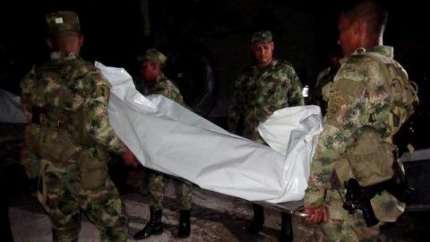 Miembros del Ejército cargan uno de los doce cuerpos de un grupo de militares abatidos durante un combate con las FARC en Maicao, frontera común.