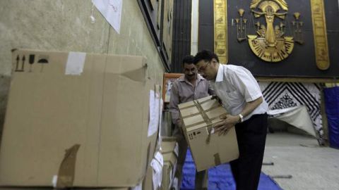 Unos trabajadores mueven cajas en las que se guardan balotas electorales en El Cairo, Egipto.