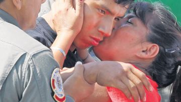 El agente Luis Astuquillca es besado por su madres a su llegada a Lima.
