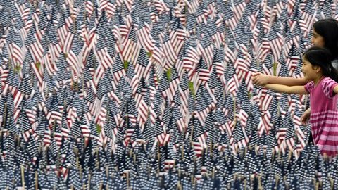 Dos niñas caminan por la instalación de 33 mil banderas estadounidenses en honor de los soldados caídos, en celebración del "Memorial Day" en Boston.