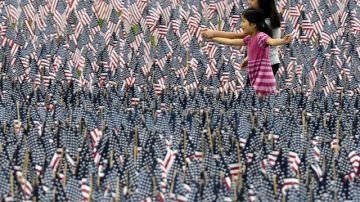 Dos niñas caminan por la instalación de 33 mil banderas estadounidenses en honor de los soldados caídos, en celebración del "Memorial Day" en Boston.