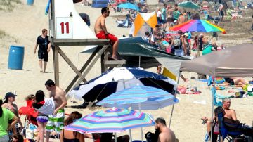 Se ve una multitud de personas en una de las playas de Wilmington, Carolina del Norte, cuando se alzaron las banderas rojas,  de advertencia de riesgo por tormenta tropical.