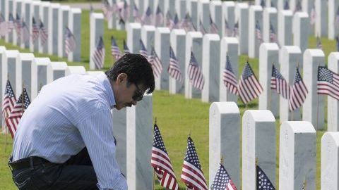 Tom Azuma presenta sus respetos frente a la tumba de su padre Eric Norton, quien peleó en la II Guerra Mundial, en Corea y Vietnam.
