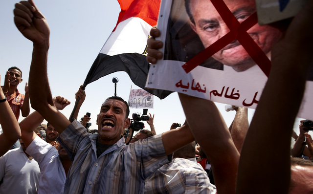 Cientos de egipcios se concentran en la plaza cairota de Tahrir, cuyos accesos han cerrado, para mostrar su ira hacia el fallo que condenó a cadena perpetua al expresidente Hosni Mubarak (abajo) y al exministro del Interior Habib al Adli