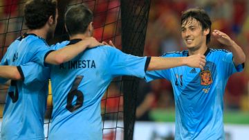 El español David Silva (der.) es felicitado después de lograr derribar la 'muralla china' a cuatro minutos del final del partido amistoso de ayer en Sevilla.