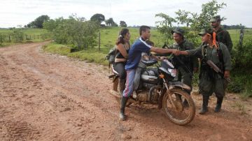 Guerrilleros de las FARC piden los documentos a una pareja en una calle del pueblo de San Isidro, al sur de Colombia, donde opera desde hace varios años.