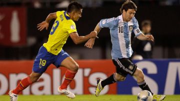 Lionel Messi (der.) esquiva la marca del ecuatoriano Fernando Saritama durante el triunfo de Argentina por 4-0.
