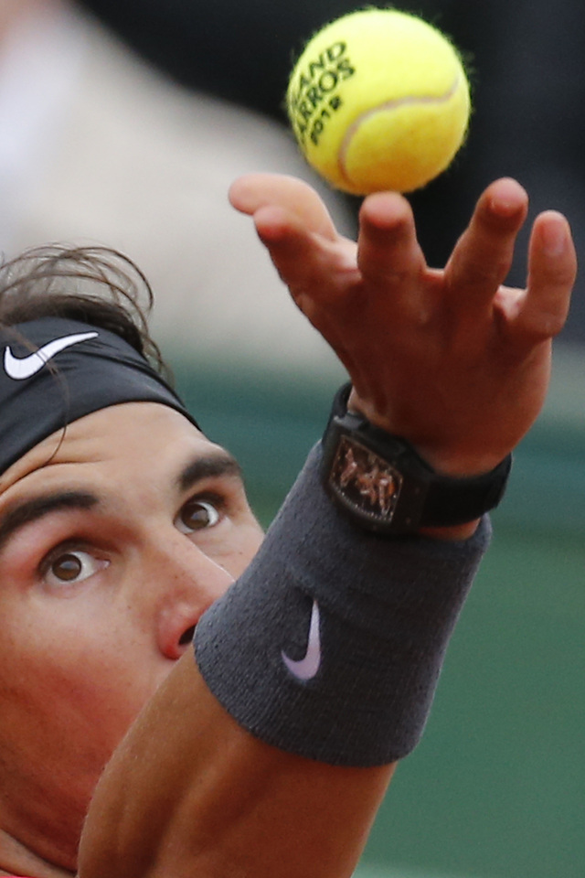 Rafael Nadal fija la vista en la bola mientras se apresta a servir en su partido de ayer en Roland Garros, donde avanzó con una victoria en sets consecutivos.