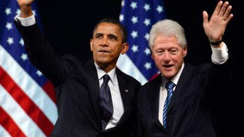 El presidente estadounidense, Barack Obama (i), y el expresidente Bill Clinton (d) saludan, durante una gira de recaudación de fondos para la campaña.