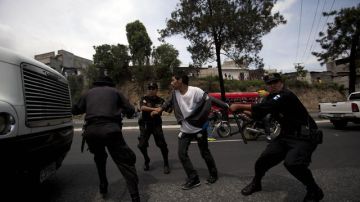 Un joven es capturado por la Policía Nacional Civil durante un enfrentamiento en Ciudad de Guatemala. Los estudiantes protestan contra reformas educativas.